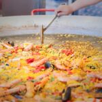 What is the ideal size of a paella pan for the number of servings to be prepared?