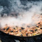 What ingredients give flavor to paella?